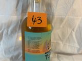 une bouteille d'alcool posée sur un lit, avec une étiquette dessus