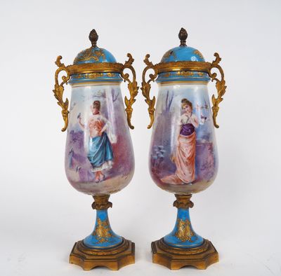 une paire de vases ornés de personnages peints, posés sur une table