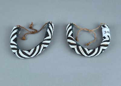 une paire de boucles d'oreilles ornées de motifs noirs et blancs sur un fond gris
