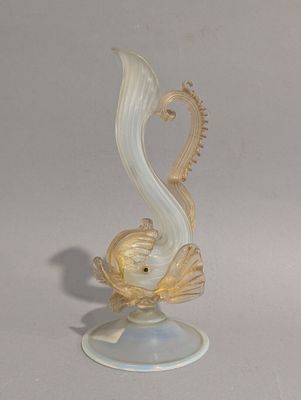 une figurine en verre représentant un poisson, posée sur un socle
