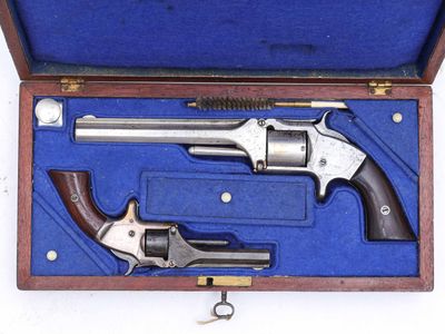 un pistolet dans un étui ouvert, posé sur une surface blanche