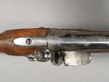 an old gun with a wooden handle on a white surface