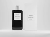 a bottle of black cologne next to a box on a white surface