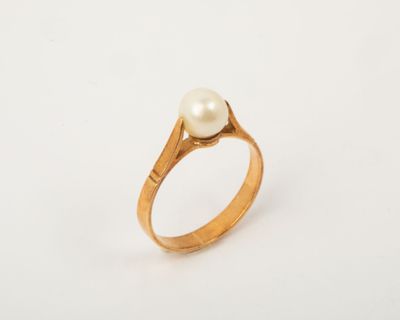 a close up of a gold ring with a pearl in it