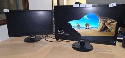 deux écrans d'ordinateur posés sur une table, avec un clavier et une souris