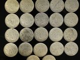 a lot of silver coins on a black surface