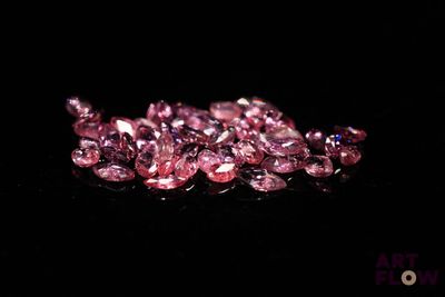 des saphirs roses sur une surface noire avec un fond noir