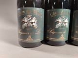 three bottles of wine are lined up on a table