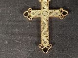 a close up of a gold cross on a black cloth