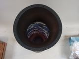 a brown bowl with a blue and white hat on top of it