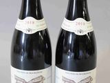 deux bouteilles de vin rouge posées l'une à côté de l'autre sur une table