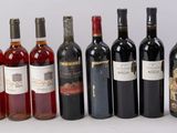 plusieurs bouteilles de vin sont alignées sur une surface blanche
