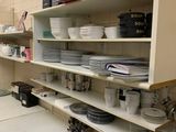 une cuisine où il y a beaucoup de vaisselle et de plats sur les étagères