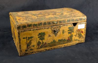 une vieille boîte en bois ornée d'une peinture, posée sur une surface noire