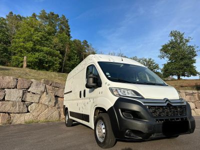the white van is parked in front of a stone wall
