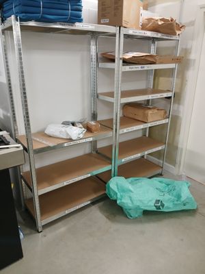une étagère métallique sur laquelle sont posées de nombreuses boîtes, dans une pièce