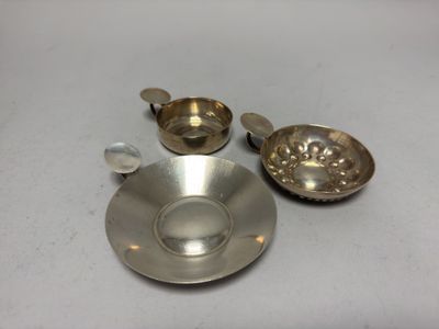 une tasse et une soucoupe argentées posées sur une table blanche
