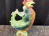 un gros plan sur une figurine représentant un coq posée sur une table
