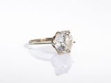 a close up of a diamond ring on a white surface