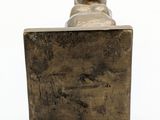 statue of a cat on a wooden block on a white surface