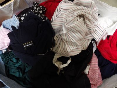 une valise remplie de vêtements, avec un sac à dos à l'intérieur