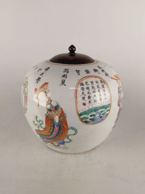 un vase blanc orné d'inscriptions asiatiques, posé sur une table