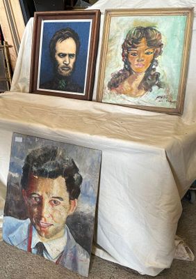 trois tableaux posés sur une table devant une tente