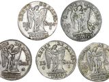 six different types of silver coins, one of which has a statue on it