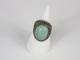 a close up of a ring with a green stone in it