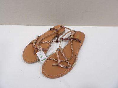 sandales en cuir beige avec des lanières tressées sur un fond blanc
