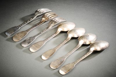 six cuillères et une fourchette sur une table