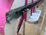 a pink and white bench that has a black and white stripe on it