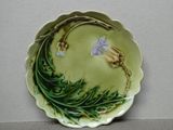 une assiette verte ornée d'une fleur, posée sur une table