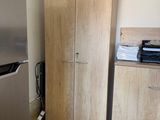 a refrigerator and cabinets in a small room