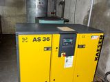 a yellow compressor sitting in a room with pipes and pipes