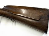 an old rifle with a wooden barrel on a white surface