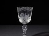 an empty wine glass sitting on top of a table next to a black background