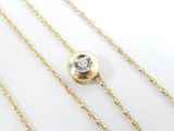 a close up of a gold chain with a single diamond on it
