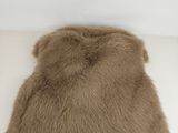 beige fur pillow on a white surface