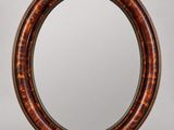 un miroir rond avec un cadre en bois sur fond gris
