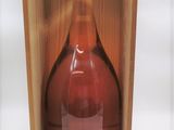 une bouteille de vin vide dans une caisse en bois posée sur une surface blanche