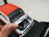 a hand holding a model of a red and white truck