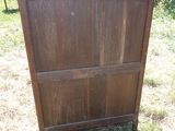 une commode en bois posée dans l'herbe, dans le jardin