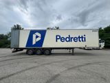 un semi-remorque blanc arborant un logo bleu et blanc, garé sur un parking