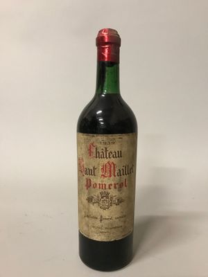 une vieille bouteille de vin posée sur une table blanche