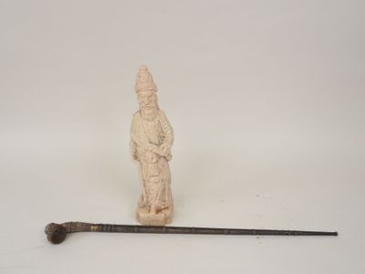 une petite statue représentant un homme tenant une canne