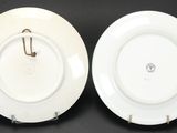 pair of white porcelain plates with gold handles on a black surface