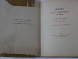 an open book on a white table with a black and red cover
