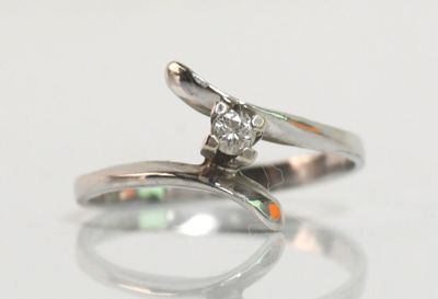 une image d'une bague en diamant sur une surface blanche