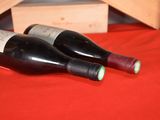 two bottles of wine sitting next to each other on a table